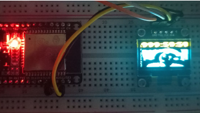 Um ESP32 com um display mostrando a imagem do MeiaUm pixelado e sofrendo com um timer mostrando mil horas em cima dele
